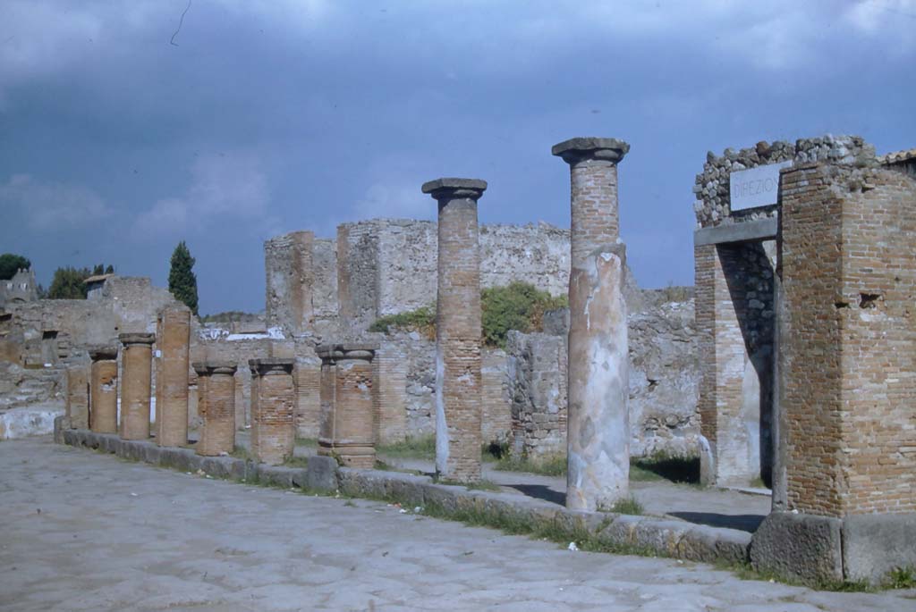 Via del Foro, Pompeii. November 1961. 
Looking north towards east side of roadway with colonnade on VII.4, with Temple of Fortuna, in background.
Photo courtesy of Rick Bauer.