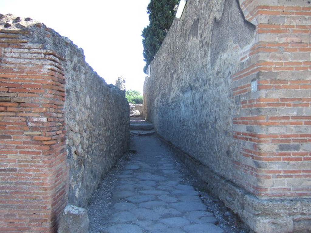 Alleyway leading to steps to the summa cavea (upper area) of Large Theatre. Looking south at VIII.7.27 on Via del Tempio d’Iside. September 2005.