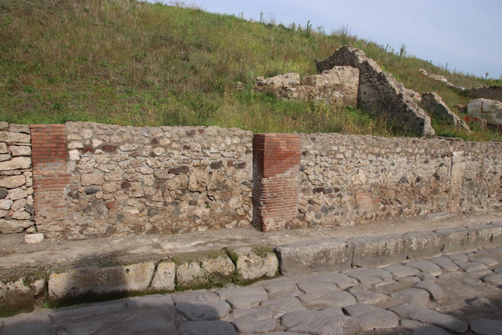 Via del Vesuvio, east side, Pompeii. October 2022.
Looking towards front façades of V.6.11, on left, V.6.10, and V.6.9, on right. Photo courtesy of Klaus Heese.