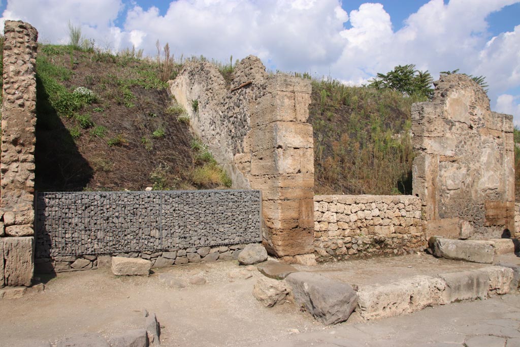Via dell’Abbondanza, north side. October 2022. 
Looking north towards unexcavated roadway, on left, with grey gabions. On the right is III.7. Photo courtesy of Klaus Heese.