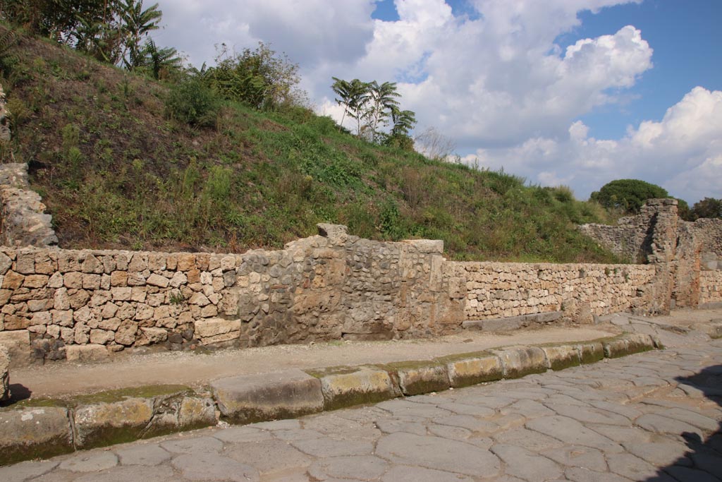 Via dell’Abbondanza, north side. October 2022. 
Continuation from photo above – 
the entrance doorway to shop at III.7.2 with grey lava doorway threshold., centre right, next to ramped entrance to III.7.3, on right. 
Photo courtesy of Klaus Heese