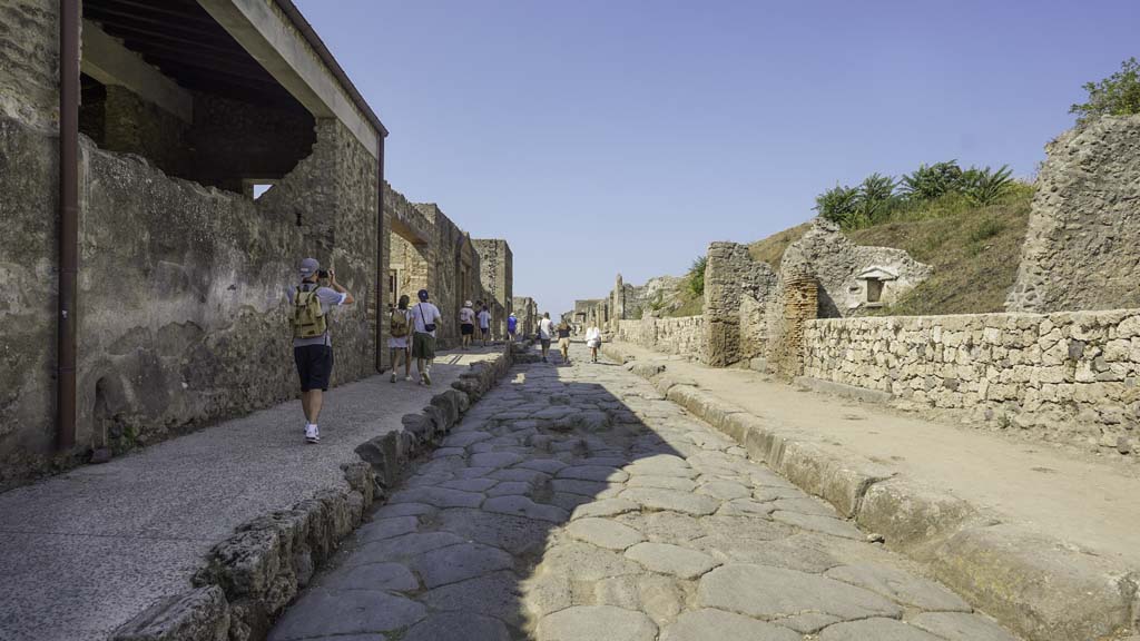 Via dell’Abbondanza, Pompeii, between II.4 and III.7, August 2021. 
Looking west along newly constructed wall along III.7 on north side of Via dell’Abbondanza. II.4.7 is on the left. Photo courtesy of Robert Hanson.