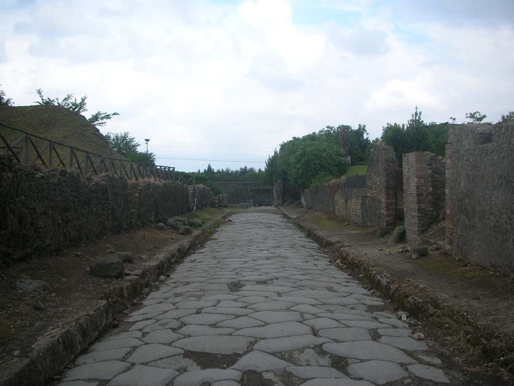 Via dell’Abbondanza between III.7 and II.5, Pompeii. May 2010.
Looking east towards remains of Porta di Sarno or Sarnus Gate (in centre). Photo courtesy of Ivo van der Graaff.