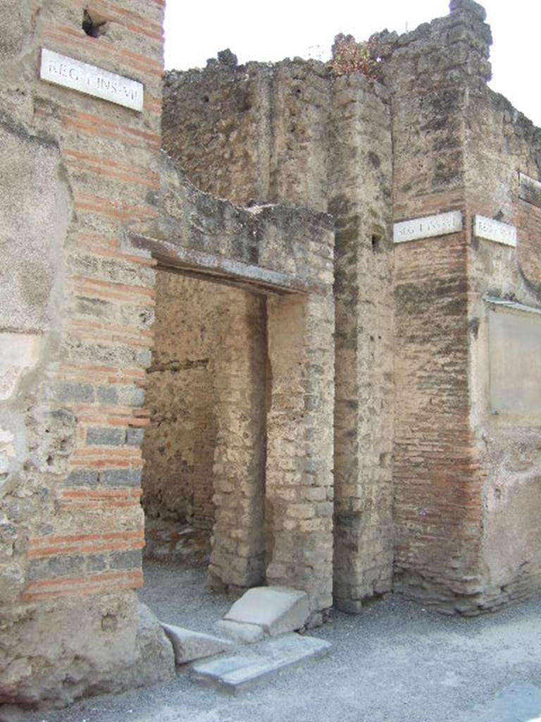 Via dell’ Abbondanza, south side. May 2006. Entrance to Vicolo di Paquius Proculus and water tower between I.7 and I.6.