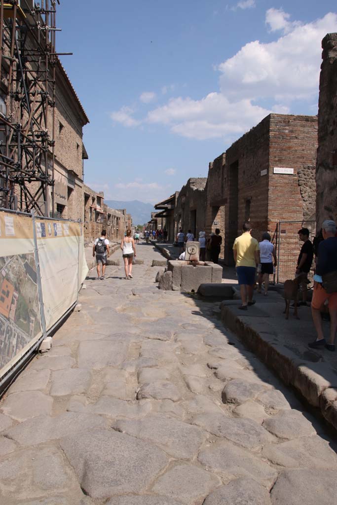 Via dell’Abbondanza, Pompeii. September 2021. 
Looking east to fountain in roadway between IX.13 and I.9. Photo courtesy of Klaus Heese.