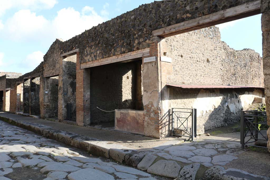 Via dell’Abbondanza, south side. December 2018. I.8.6 to I.8.1, on left, with junction of roadway between I.8 and I.7, on right. 
Photo courtesy of Aude Durand.