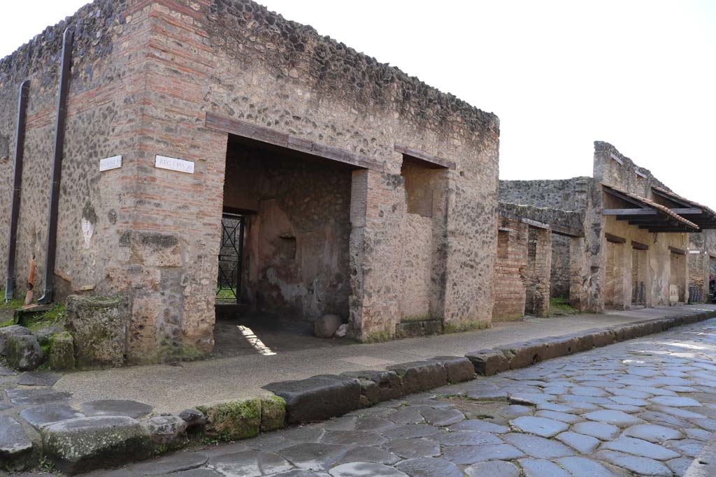 Via dell’Abbondanza, south side. December 2018. 
Looking south-west from junction with Vicolo della Nave Europa, on left, towards doorways to I.11.7 to I.11.1, on right. 
Photo courtesy of Aude Durand.