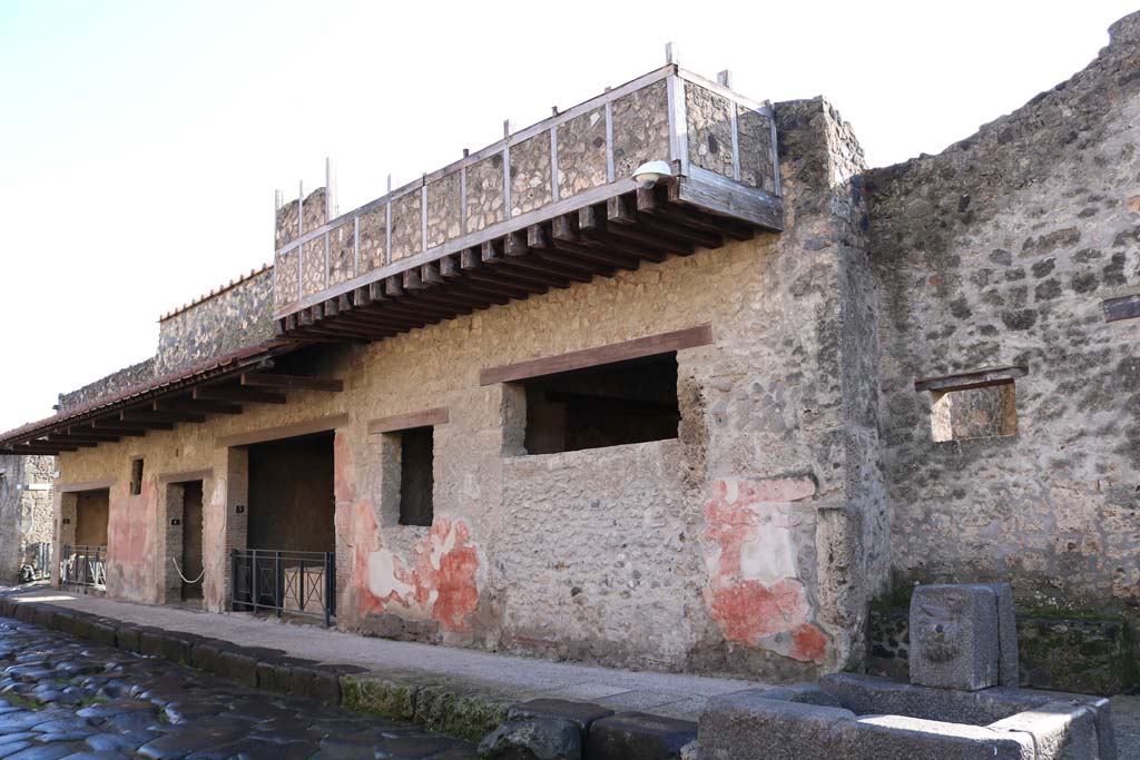 Via dell’ Abbondanza. December 2018. 
Looking east along south side of Via dell’Abbondanza, between I.12.5 on left, and I.12.3, in centre. Photo courtesy of Aude Durand.