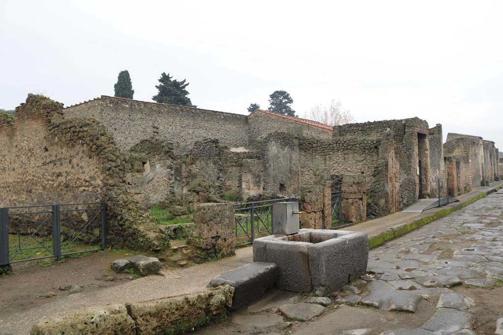 Via dell’Abbondanza, south side. December 2018. 
Looking west along insula II.3, from near fountain at II.3.5. Photo courtesy of Aude Durand.