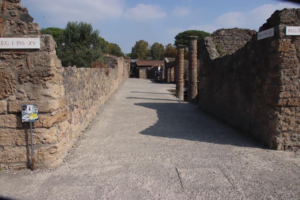 Via della Palestra, Pompeii. October 2023. 
Looking east between I.15 and I.21, from junction with Vicolo della Nave Europa. Photo courtesy of Klaus Heese.