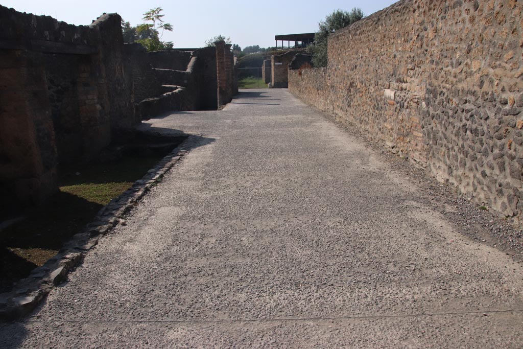 Via della Palestra, Pompeii. October 2023. 
Looking west between I.21 and I.15 towards junction with Vicolo della Nave Europa. Photo courtesy of Klaus Heese.