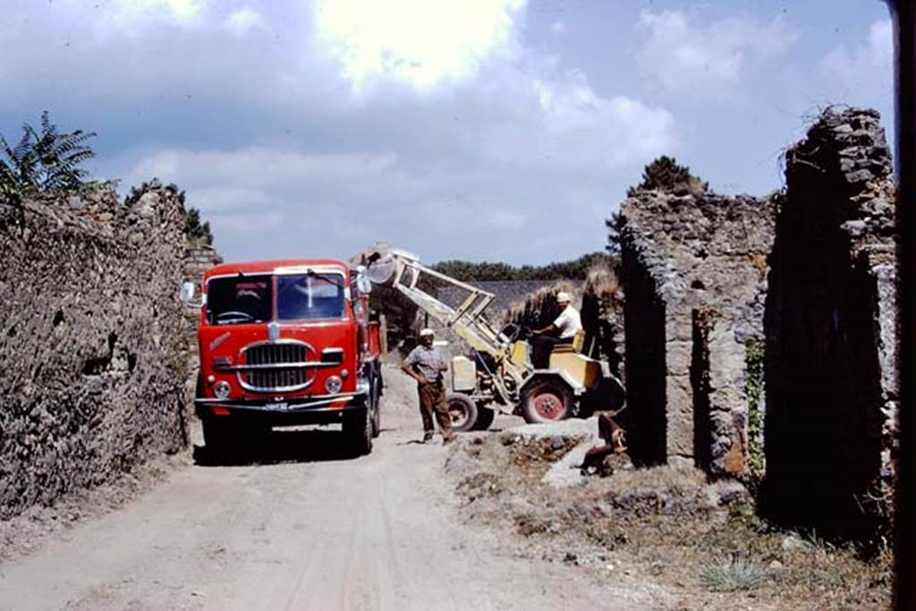 Via della Palestra, Pompeii. 1972. Looking west from between1.16 and I.22 during removal of lapilli. Photo by Stanley A. Jashemski. 
Source: The Wilhelmina and Stanley A. Jashemski archive in the University of Maryland Library, Special Collections (See collection page) and made available under the Creative Commons Attribution-Non Commercial License v.4. See Licence and use details. J72f0714