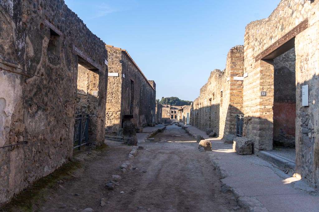 Via di Castricio, Pompeii. October 2023. 
Looking west from between I.14.8, on left, and I.13.13, on right. Photo courtesy of Johannes Eber.
