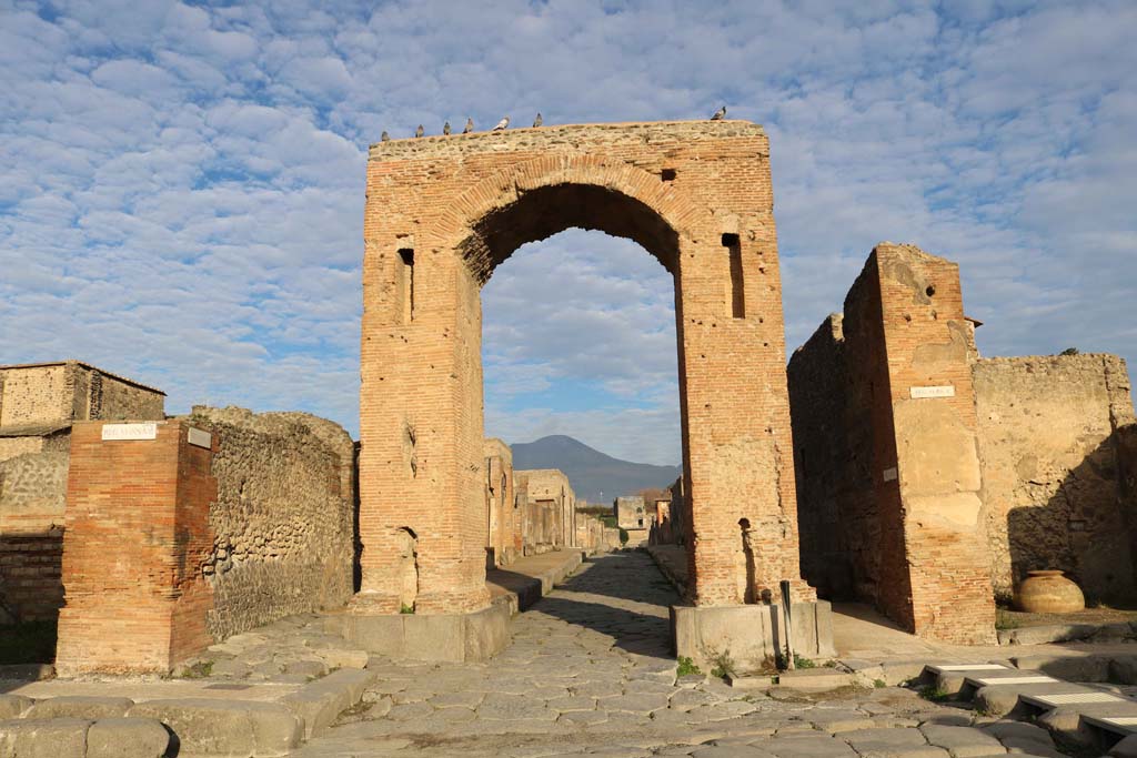 Via di Mercurio at the south end between VI.8, on left, and VI.10, on right. December 2018. 
Looking north through the Arch of Caligula into Via di Mercurio, from crossroads of Via delle Terme, on left, and Via della Fortuna, on right. 
Photo courtesy of Aude Durand.