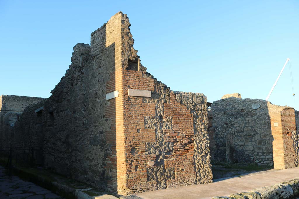 Via di Nola, Pompeii. December 2018. 
Looking north-east to front façade of V.2.1 on east side of junction with Vicolo di Cecilio Giocondo, on left. Photo courtesy of Aude Durand.