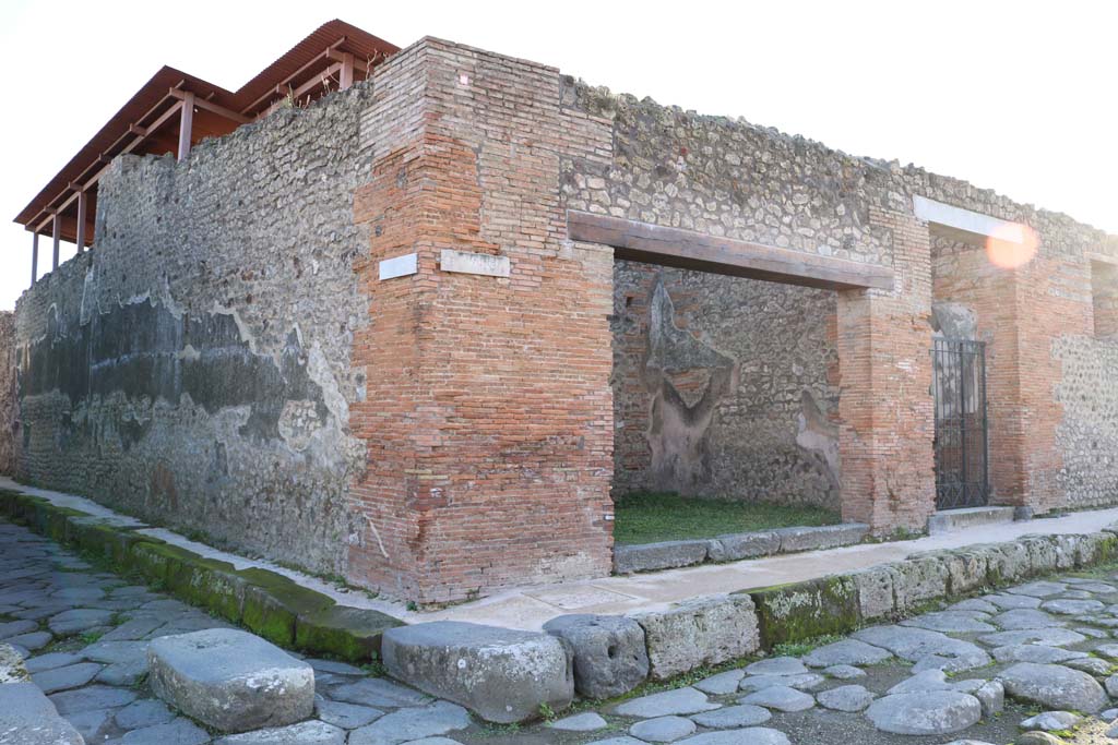 Via di Nola at IX.5.12, in centre, Pompeii. December 2018. 
Looking south-west towards shop on junction between Vicolo del Centenario, on left, and Via di Nola, on right.
Photo courtesy of Aude Durand.