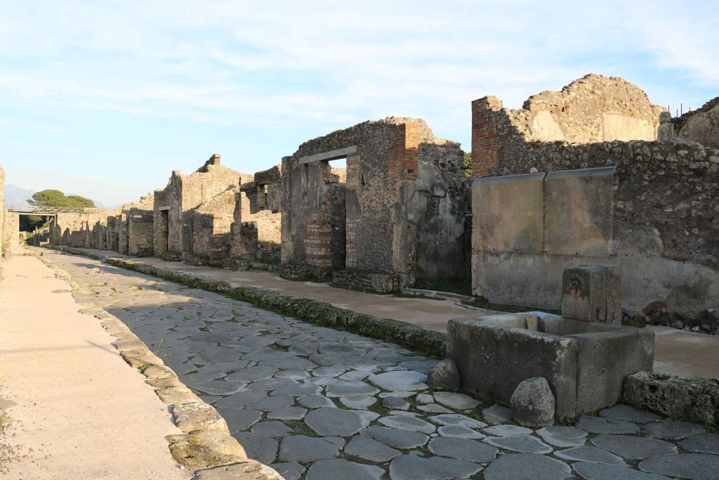 Via di Nola, south side, Pompeii. December 2018. 
Looking east from fountain outside IX.8.1, along Insulae 8, 9 and 10 of Reg. IX. Photo courtesy of Aude Durand.