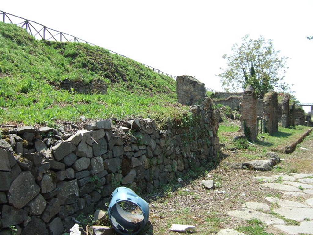 Via di Nola. South side. Looking west to junction with unnamed vicolo between III.12 and III.11. This used to be seen behind the modern built wall. May 2006.