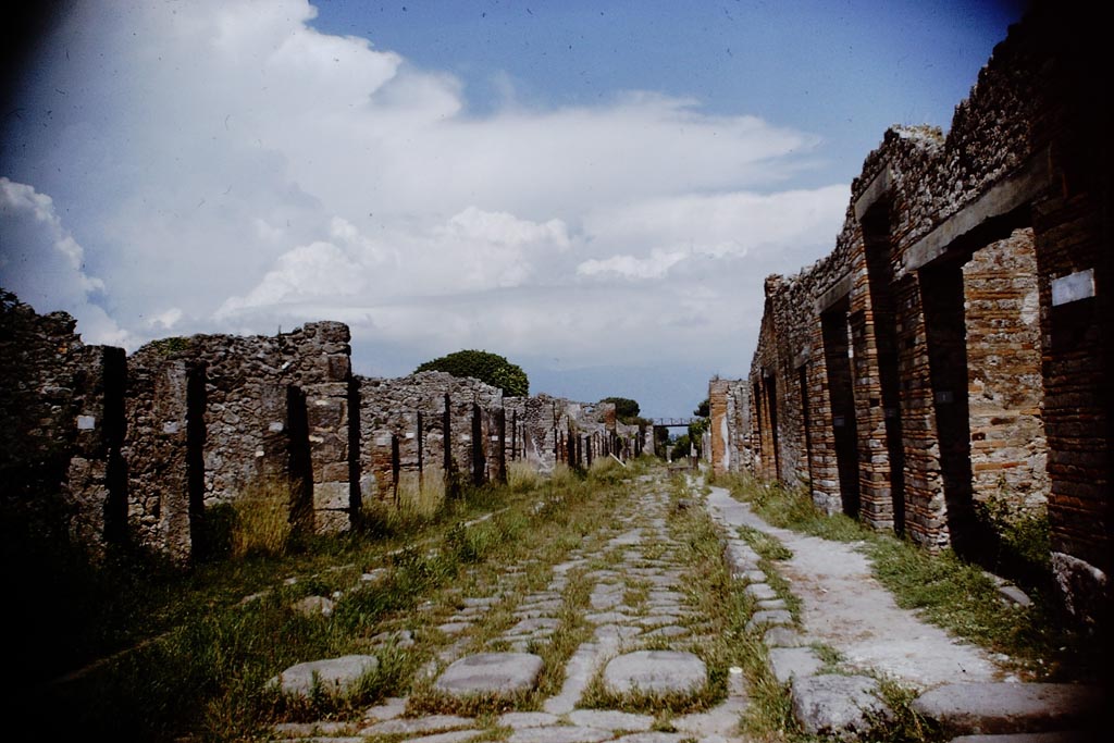 Via di Nola, Pompeii. 1964. 
Looking east between V.2 and IX.5, from junction with Vico di Tesmo, on right. Photo by Stanley A. Jashemski.
Source: The Wilhelmina and Stanley A. Jashemski archive in the University of Maryland Library, Special Collections (See collection page) and made available under the Creative Commons Attribution-Non Commercial License v.4. See Licence and use details.
J64f1226