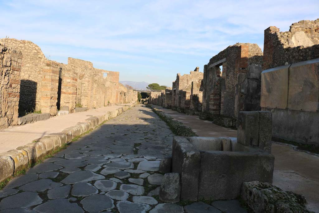 Via di Nola, Pompeii. December 2018. 
Looking east from near fountain outside IX.8.1, on right, with V.3.2, on left. Photo courtesy of Aude Durand.