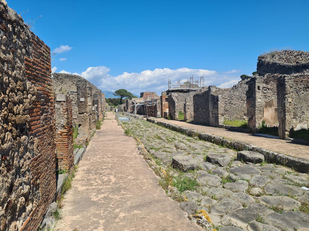 Via di Nola, Pompeii. May 2024. Looking east between V.4, on left and IX.9, on right. Photo courtesy of Klaus Heese.