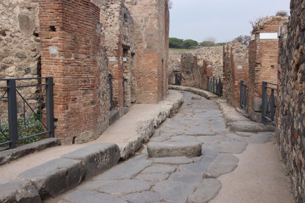 Vicolo Storto between VII.4 and VII.3, Pompeii. October 2023. 
Looking north from junction with Vicolo del Panettiere. Photo courtesy of Klaus Heese.