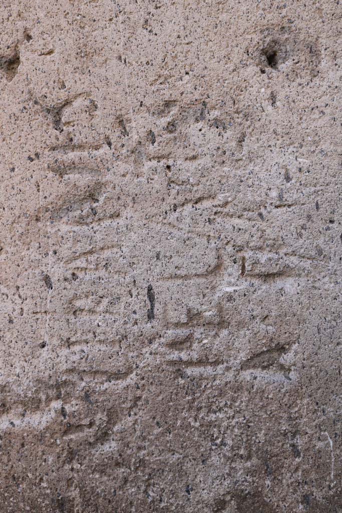 Vicolo degli Scheletri, Pompeii. December 2018. 
Stone block with inscription at corner of Vicolo della Maschera and Vicolo degli Scheletri. 
Photo courtesy of Aude Durand.