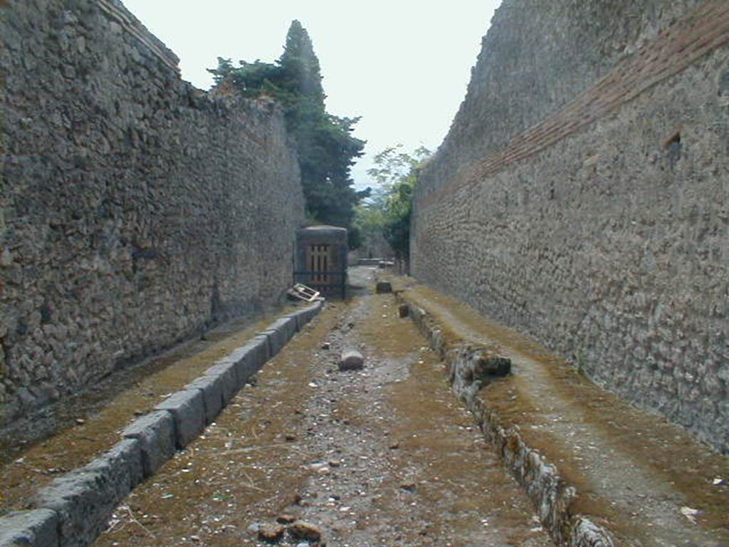 I.10 Pompeii. May 2005.         Vicolo del Citarista looking south.           Side wall of I.3.24