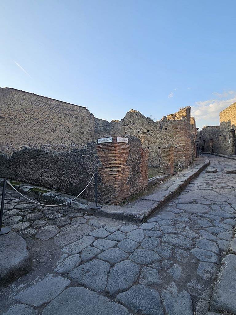 Vicolo del Lupanare, Pompeii. November 2024. 
Looking north from junction with Vicolo degli Scheletri towards entrance doorways of VII.11.17 and 16. 
Vicolo degli Scheletri is on the left. Photo courtesy of Annette Haug.