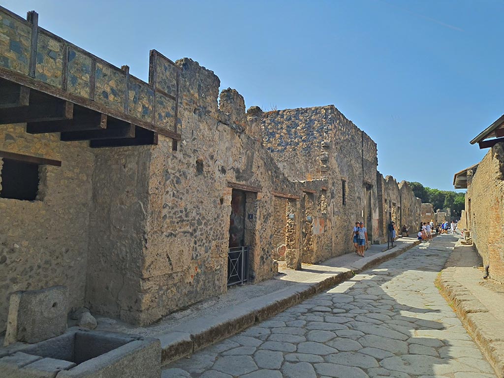 Vicolo del Menandro, Pompeii. September 2024. 
Looking west between I.10 and I.6, from junction with Vicolo di Paquius Proculus. Photo courtesy of Giuseppe Ciaramella.