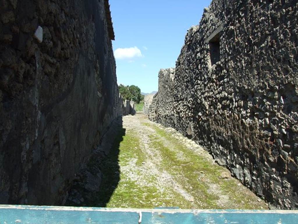 Vicolo della Fullonica between VI.5 and VI.7.  Looking north from VI.5.16 towards the city walls. March 2009.