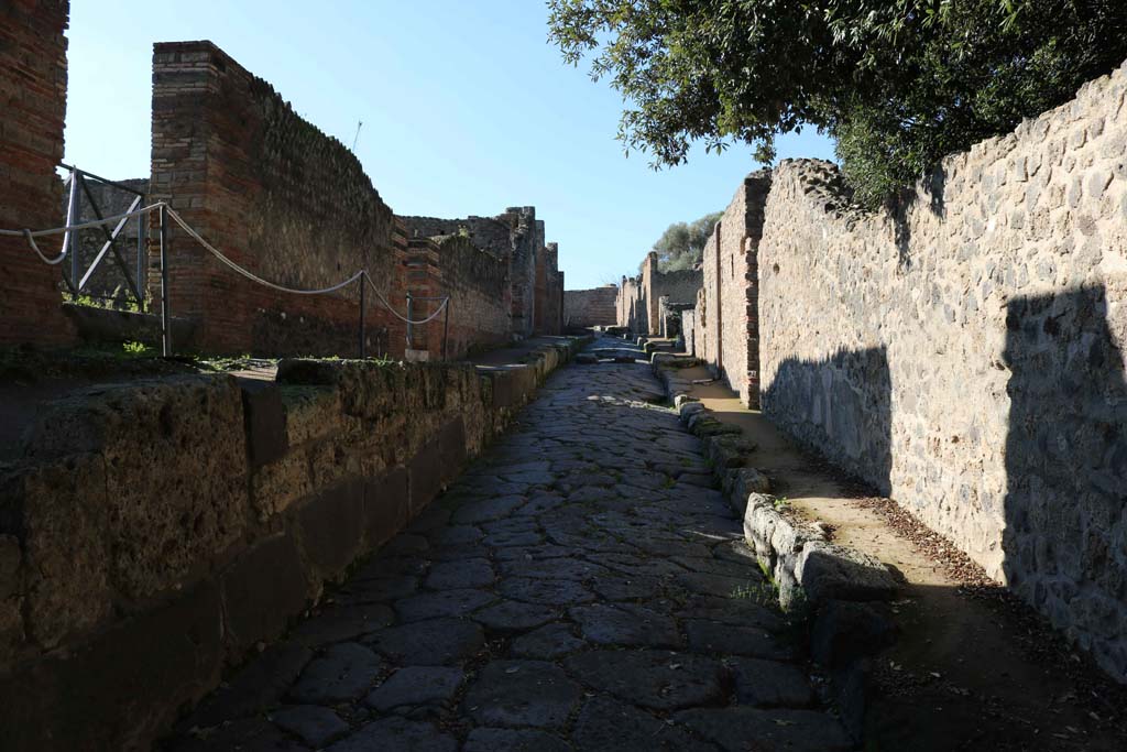 Vicolo della Regina, Pompeii. December 2018. 
Looking west along roadway between VIII.2, on left, and VIII.6, on right. Photo courtesy of Aude Durand.