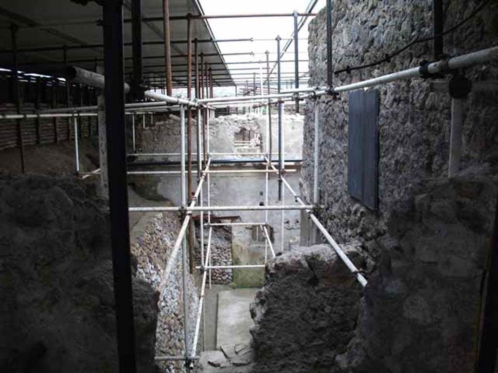 Vicolo di Giulio Polibio, Pompeii. May 2010. Excavation behind IX.13.1.  Looking east from unnamed vicolo.
According to Cerulli Irelli, 
“A work of excavation had been followed to isolate the humidity from the two splendid rear rooms of the said house (i.e. of IX.13.1/3 Julius Polybius), and the rustic quarters of a house has appeared to the north of this last house and presented a small kitchen with cupboard (repositorium) in a notable state of conservation, and a vast lararium picture with several elements on the rear wall of an uncovered/open room: this seemed to be evidence of plebeian art not inferior to the lararium picture found in the actual house of Julius Polybius.”
See Cerulli Irelli, G: Cronache Pompeiane, 2, (II), 1976, Notiziario, attività archeologica. (p.241).