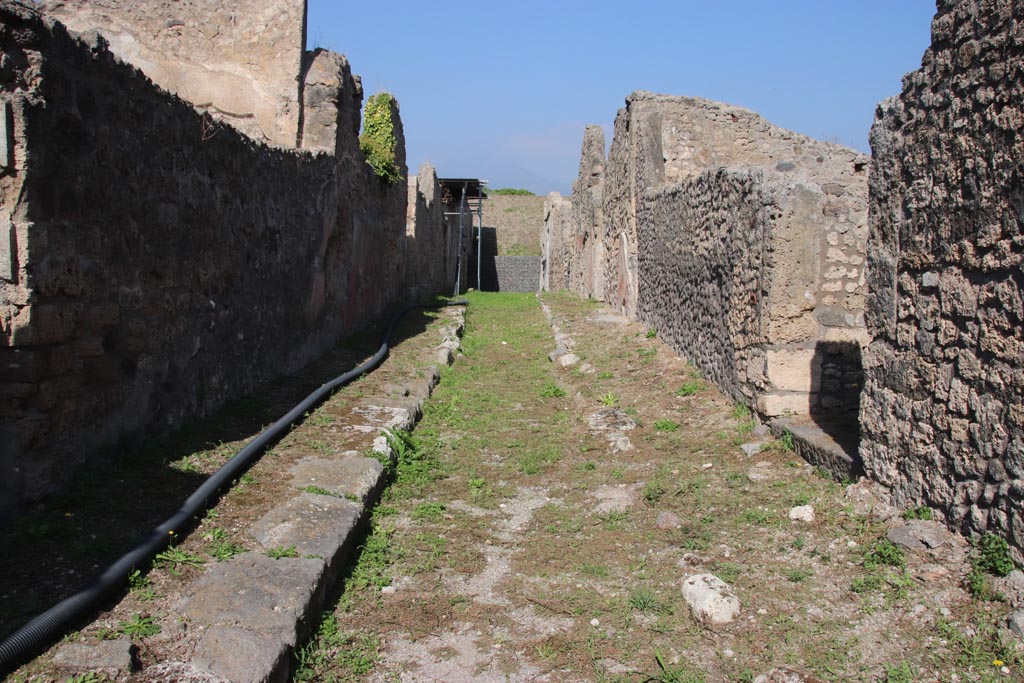 Vicolo di Lucrezio Frontone, Pompeii. October 2023. 
Looking between V.3, on left and V.4, on right, towards north end of Vicolo. Photo courtesy of Klaus Heese.