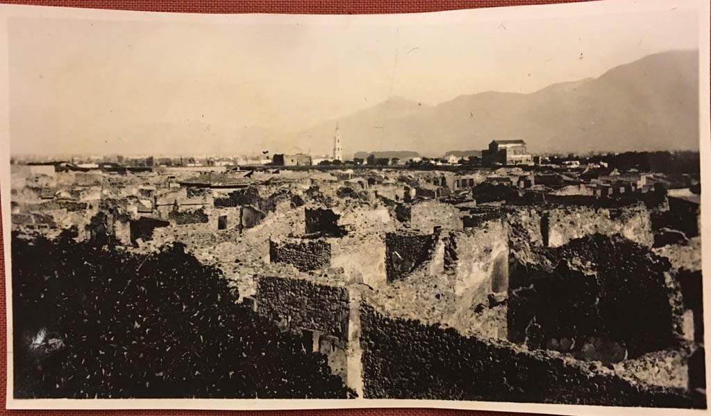 Vicolo di Mercurio, south side across lower part of photo, Pompeii. Photo from album dated 1928. 
Looking south-east across VI.14, with bakery at VI.14.34, in centre, and rear room of VI.14.35/36, on right. 
Photo courtesy of Rick Bauer.