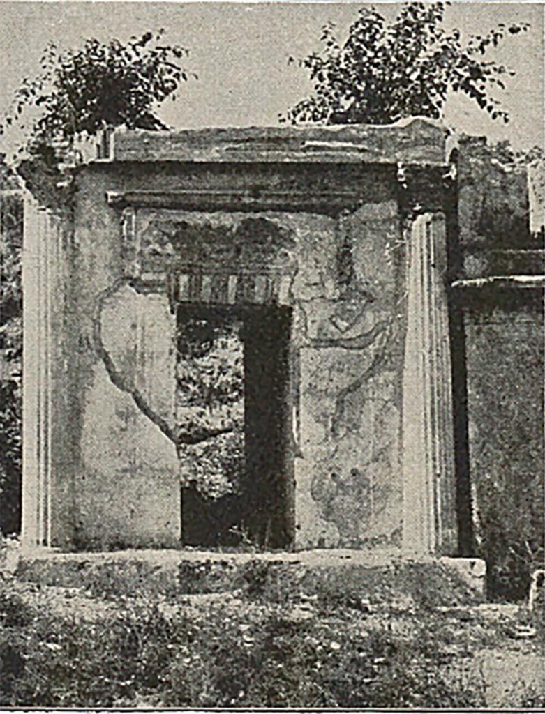 FP4 Pompeii. Detail from late 19th century photo.
According to Mau, the tomb is of interest as showing the result of an attempt to blend the arch type with that of the temple. 
A passage roofed with a flat vault runs through the middle of the first storey. 
The second story had the appearance of a diminutive temple with four Corinthian columns in front. 
The niche representing the cella was of the full width of the tomb and occupied two thirds of the depth; the other third was given to the portico. 
Four 1.85m to 2.10m high statues of tufa coated with stucco were found. 
Three were statues of men, one an old man, one middle aged and one a youth and the fourth was of a woman.
See Mau, A., 1907, translated by Kelsey F. W. Pompeii: Its Life and Art. New York: Macmillan. (p. 433).
See Mau, A., 1888. Mitteilungen des Kaiserlich Deutschen Archaeologischen Instituts, Roemische Abtheilung Volume III, p. 181.