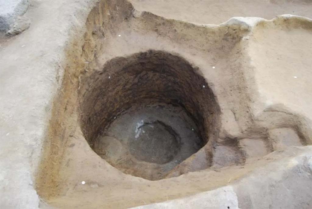 HGE20 Pompeii. June 2016. A circular pit, which is accessed by a few steps, must be related to bronze work. 
The excavation of the HGE20 store identified a polymetallic production workshop, where bronze and iron were worked, installed in the back room of the building and in the room opening onto the portico. A circular pit, which is accessed by a few steps, must be related to bronze work. This is a casting pit, also used for firing the moulds needed to make bronze objects. This is the first permanent installation, unrelated to a construction site, discovered so far. In the main room, remains linked to the work of iron - slag, scale - make it possible to restore an activity linked to the work of this metal, probably thanks to a forge on a table. The two activities appear to have coexisted in the same store, although the workshop was no longer in operation at the time of the eruption.
Une fosse circulaire, à laquelle on accède par quelques marches doit être mise en relation avec le travail du bronze.
La fouille de la boutique N20 a permis d’identifier un atelier de production polymétallique, où l’on travaillait le bronze et le fer, installé dans l’arrière-boutique de l’édifice et dans la pièce ouvrant sur le portique. Une fosse circulaire, à laquelle on accède par quelques marches doit être mise en relation avec le travail du bronze. Il s’agit d’une fosse de coulée, servant également pour la cuisson des moules nécessaires à la fabrication d’objets en bronze. Il s’agit de première installation pérenne, non liée à un chantier de construction, découverte jusqu’alors. Dans la pièce principale, des restes liés au travail du fer - scories, battitures - permettent de restituer une activité liée au travail de ce métal, vraisemblablement grâce à une forge sur table. Les deux activités semblent avoir coexisté dans la même boutique, même si l’atelier n’était plus en activité au moment de l’éruption.
See Pompei- le secteur de la Porte d’Herculanum à Pompéi Centre Jean Bérard