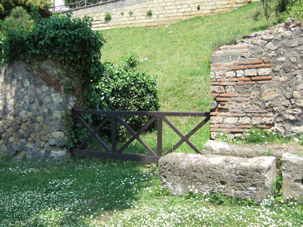 HGE22 Pompeii. May 2006. Looking north-east towards entrance doorway.
According to Garcia y Garcia, on 18th September 1943 a bomb smashed the poor remains of the shops at HGE22, 23, 24 and the colonnade outside them.
The damage was not recorded in the official report, but can be seen in a photo (fig.398 -Foto SAP neg 57-A).  See Garcia y Garcia, L., 2006. Danni di guerra a Pompei. Rome: L’Erma di Bretschneider. (p.163)