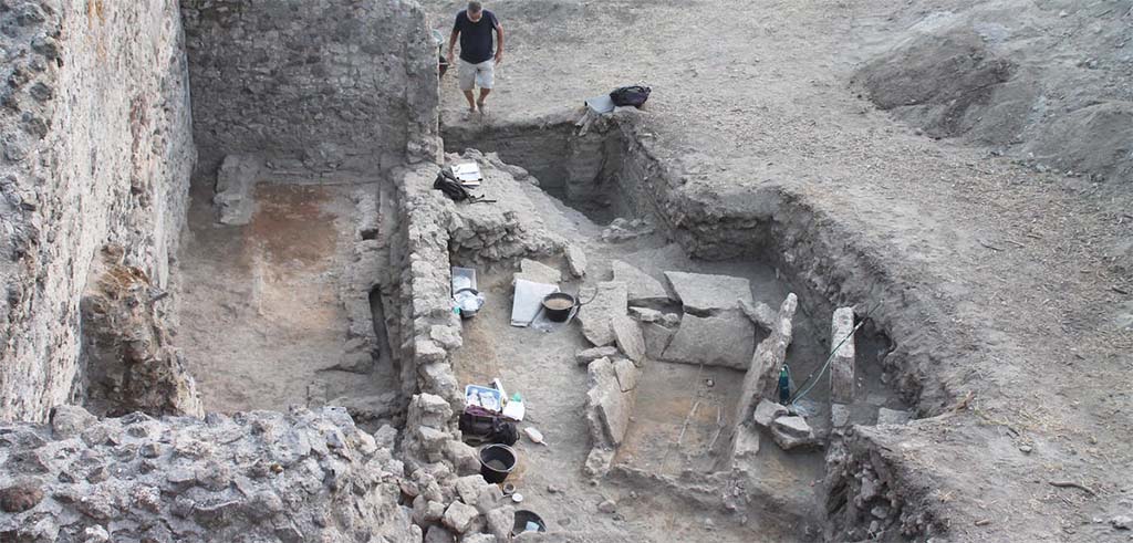 HG31A Pompeii. Tomb of a Samnite Woman. 2015. HGE30 left and tomb right.
The Samnite tomb was found in an area containing tombs from the Roman period, lavish villas and craftsmen’s shops.
It was uncovered when the wall of one of the shops was examined more closely; it was just on the other side of the partition.
No trace of the tomb cover was found.
Photograph © L.CAVASSA/CNRS-AMU .