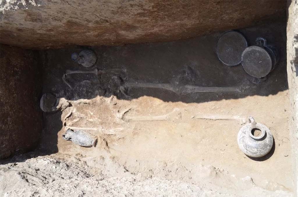 HGE32A Pompeii. June 2016. Tomb of a Samnite Man. The distribution is as follows: 
there is an oenochoe lying against the right arm, a lekythos in a vertical position near the left arm, then three vases next to the left leg: a cup on a high foot, a kylix, and a skyphos, while near the right leg, there was a jug. 
La répartition est la suivante : 
on retrouve une oenochoe en position allongée contre le bras droit, un lécythe en position verticale à proximité du bras gauche, puis trois vases à côté de la jambe gauche : une coupe sur haut pied, une kylix, et un skyphos, tandis qu’à proximité de la jambe droite, se trouvait une cruche. 
See Pompéi, Porta Ercolano : organisation, gestion et transformations d’une zone suburbaine: Campagne 2016 CEFR 1676 and below.
Photograph © Parco Archeologico di Pompei.