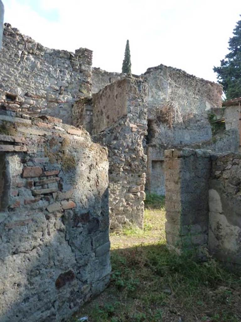 HGW25 Pompeii. September 2015. Looking into servants’ quarters, room with lararium. Photo taken from the same place as above photo, but without the overgrown bushes and trees.