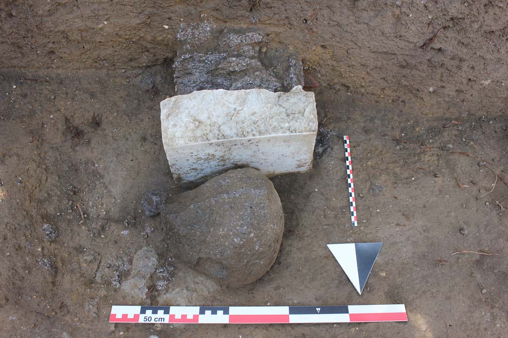 Tomb NG2 Pompeii. July 2017. In the excavations carried out in 2017, approximately 2m to the west of the tomb of Betutius, a further fragment of marble burial marker was found, behind which at a depth of 0.85m was the cremation urn. Photo courtesy Stephen Kay, British School at Rome.
See Pompeii Porta Nola Necropolis Project in Papers of the British School at Rome: Vol. LXXXVI, 2018, p. 314.
