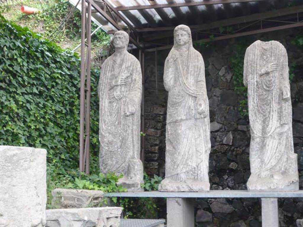 Pompeii Porta Nocera. May 2011. South side of the Via delle Tombe between tombs OS and ES.
Three statues from tomb 34aEN, now in display area for items found in and near the tombs. 
Photo courtesy of Buzz Ferebee.