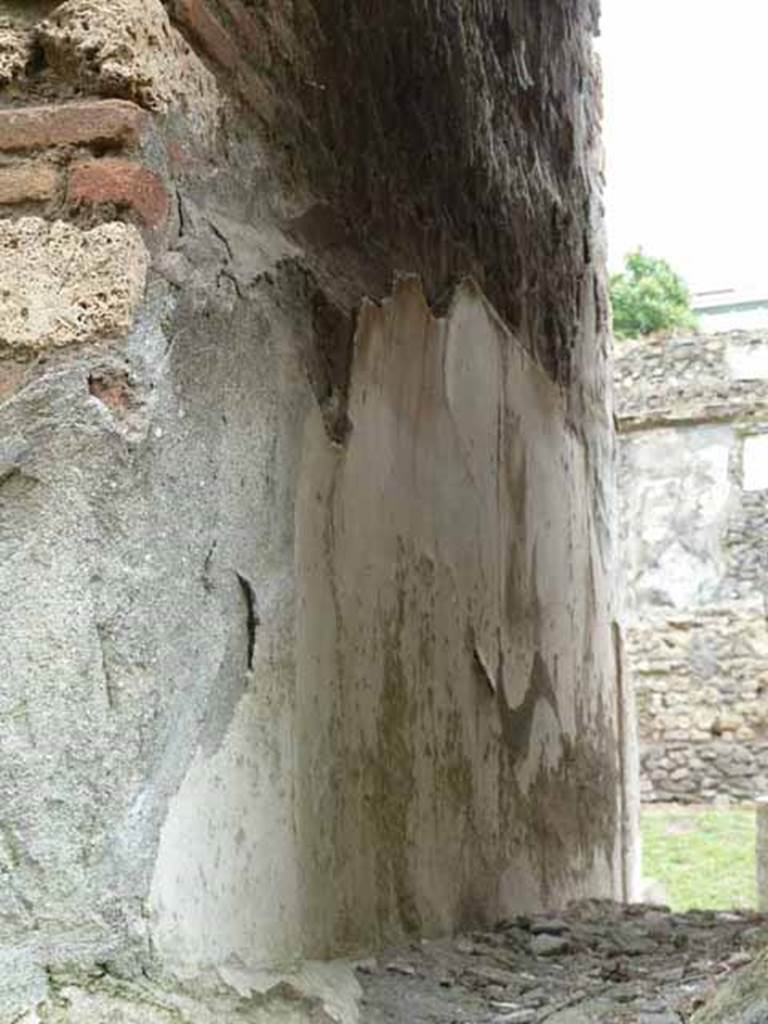 Pompeii Porta Nocera. May 2010. Detail of remains of plaster on west wall of 12EN. 
Looking south.