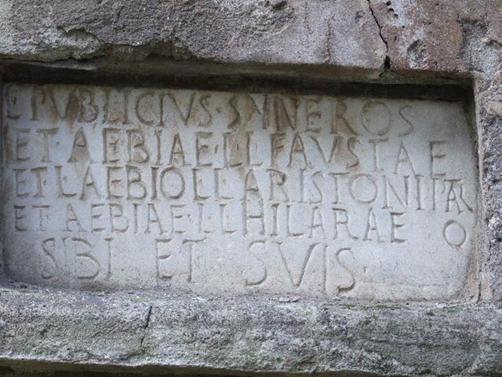 Pompeii Porta Nocera. Tomb 22EN. May 2006.
Tomb of Lucius Publicius Syneros, Aebia Fausta, Lucius Aebius Aristo and Aebia Hilara.
Plaque with latin inscription:
L(ucius)  PVBLICIVS  SYNEROS
ET  AEBIAE  L(uci)  L(ibertae)  FAVSTAE
ET  L(ucio)  AEBIO  L(uci)  L(iberto)  ARISTONI  PATR(i)
ET  AEBIAE  L(uci)  L(ibertae)  HILARAE
SIBI  ET  SVIS.
There is an extra O, at the end of the fourth line, after HILARAE.