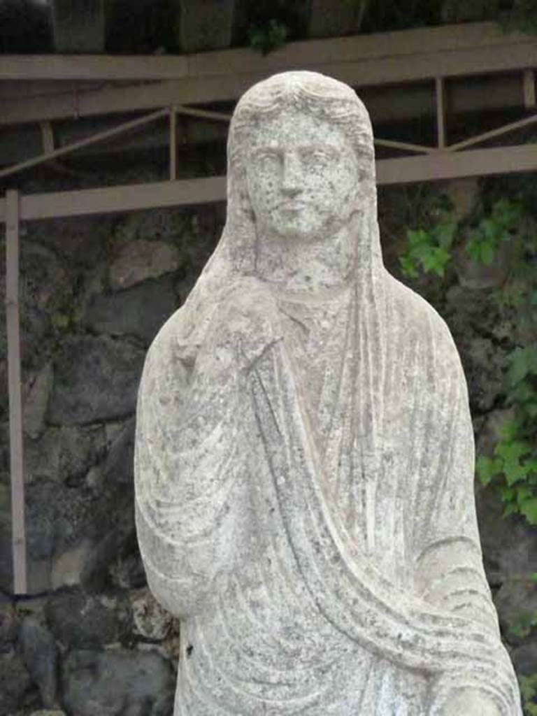 Pompeii Porta Nocera Tomb 34aEN. May 2010.
Detail from statue of a female in tunic and cloak covering part of the head.