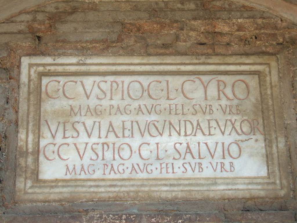 Pompeii Porta Nocera. May 2006. Tomb 17ES. Marble plaque with Latin inscription:
C(aio) CVSPIO C(ai) L(iberto) CYRO
MAG(istro) PAG(i) AVG((usti) FEL(icis) SVB VRB(anis)
VESVIAE IVCVNDAE VXOR(i)
C(aio) CVSPIO C(ai) L(iberto) SALVIO
MAG(istro) PAG(i) AUG((usti) FEL(icis) SVB VRB(anis).
Caius Cuspius Cyrus and Caius Cuspius Salvius were both freedmen of Caius Cuspius.
Vesvia Iucunda the wife of C. Cuspius Cyrus would appear also to be free.
Both men would appear to have been magistrates/priests of the Pagus Augustus Felix Suburbanus.