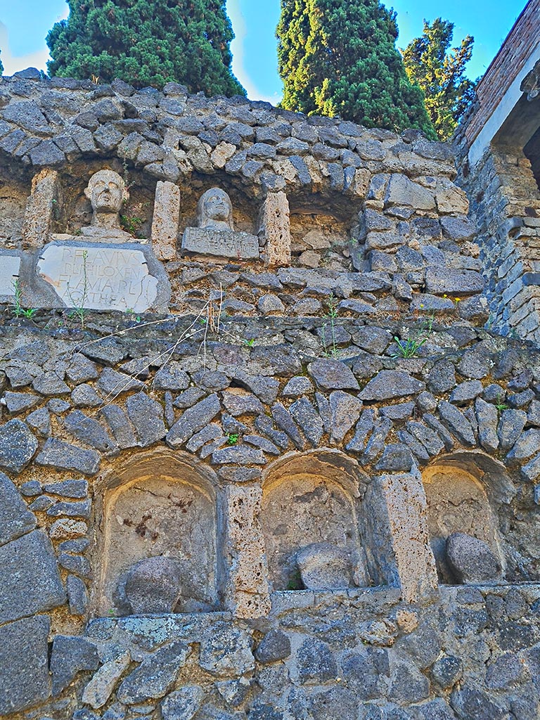 Pompeii Porta Nocera. October 2024. 
Tomb 7OS. Looking south towards west side, with busts, plaques with inscriptions and niches.
Photo courtesy of Giuseppe Ciaramella.