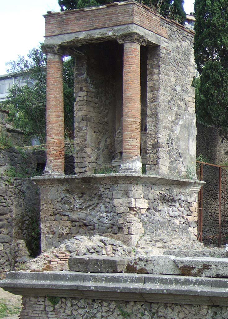 Pompeii Porta Nocera. May 2006. Tomb 9OS. Tomb of a magistrate? 
View from west side showing the tomb set back from tombs 7OS and 11OS.
This would suggest it is of a pre-Augustan late republican age.
See D’Ambrosio, A. and De Caro, S., 1983. Un Impegno per Pompei: Fotopiano e documentazione della Necropoli di Porta Nocera. Milano: Touring Club Italiano. (9OS