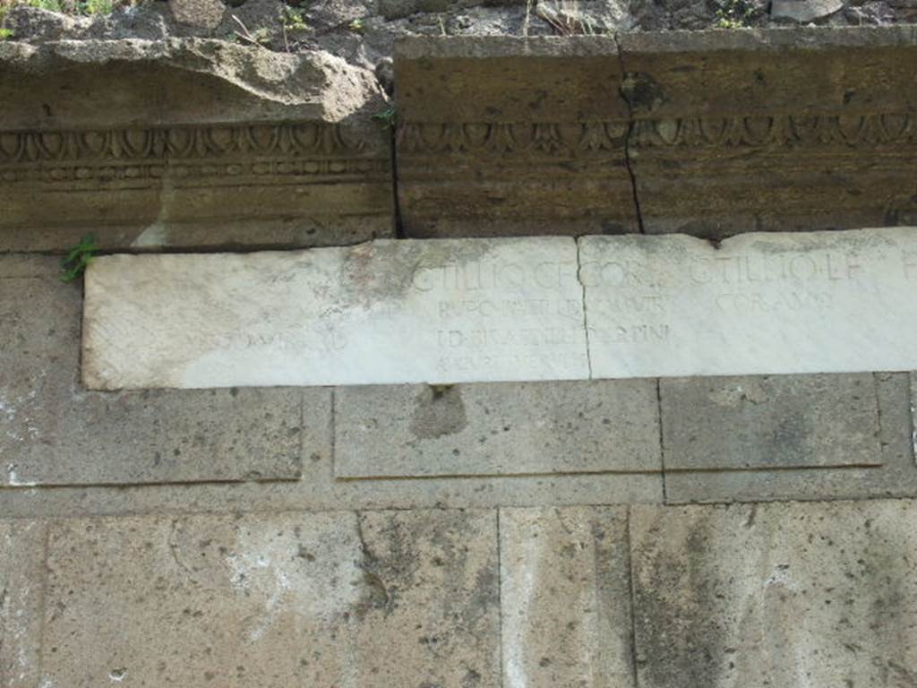 Pompeii Porta Nocera. Tomb 17OS. May 2006. Marble plaque with inscriptions, left hand side. 
From left to right the inscriptions read:
L(ucius?)  TILLIVS  C(ai)  F(ilius)  COR(nelia)
TR(ibunus)  MIL(itum)  LEG(ionis)
X  EQVUEST(ris)
DVOVIR  I(ure)  D(icundo).
C(aio)  TILLIO  C(ai)  F(ilius)  COR(nelia)
RVFO  PATRI,  DVOMVIR(o)
I(ure)  D(icundo)   BIS  AEDILI I(ure)  D(icundo)  ARPINI
AVGURI  VERVLIS.
C(aio)  TILLIO  L(uci)  F(ilius)
COR(nelia)  AVO.
FADIAE  C(ai)  F(iliae)
MATRI.
C(aio)  TILLIO  C(ai)  F(ilio)  COR(nelia)
RVFO  FRATRI  TR(ibuno)  MIL(itum)
LEG(ionis)  X  AVGVRI  VERVLIS.
See D’Ambrosio, A. and De Caro, S., 1983. Un Impegno per Pompei: Fotopiano e documentazione della Necropoli di Porta Nocera. Milano: Touring Club Italiano. (17OS)